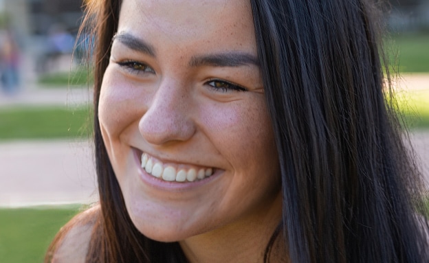 a close up of a woman who is smiling and looking at the camera